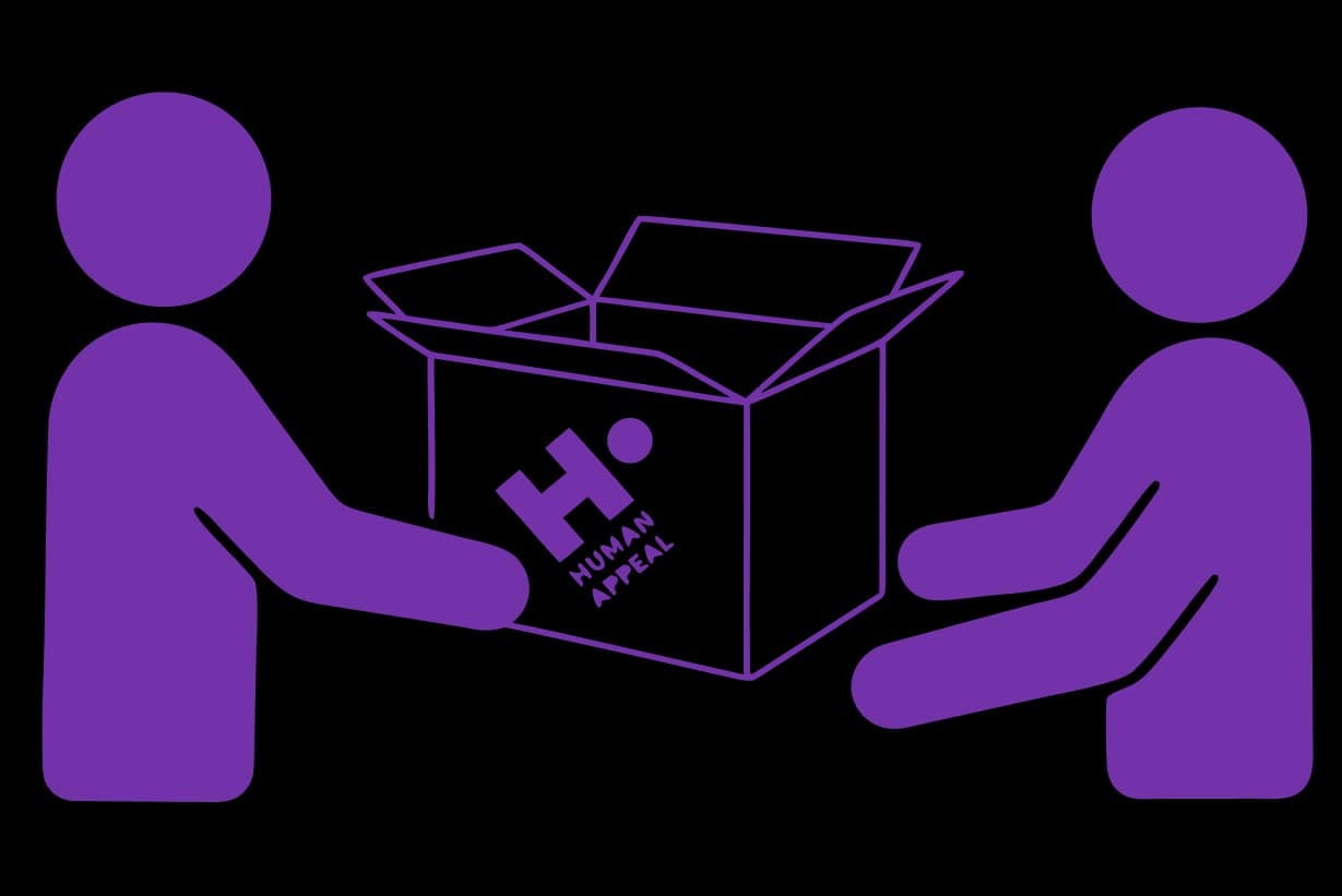 A Human Appeal aid worker hands over a box of relief supplies